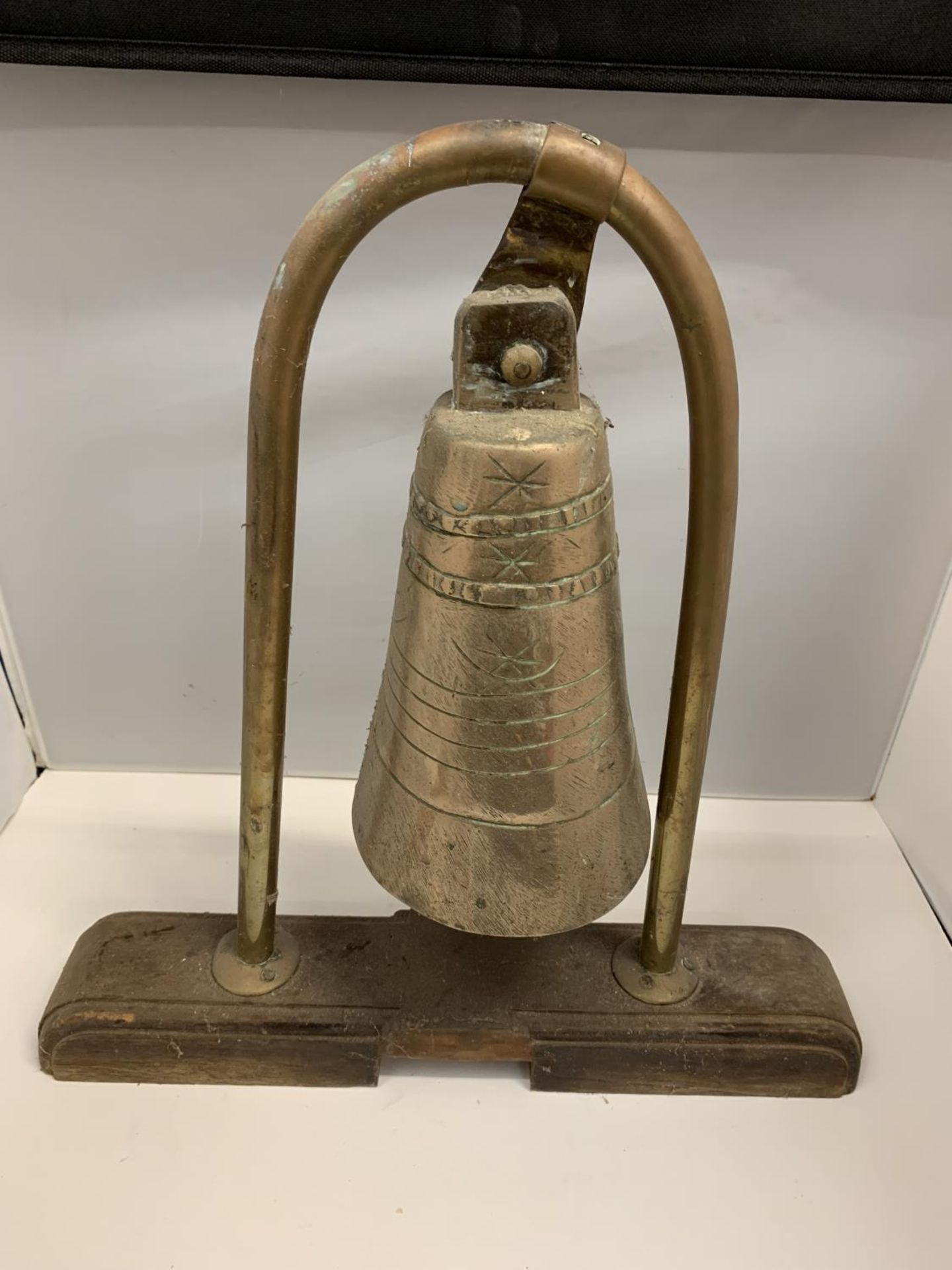 A VINTAGE UNUSUAL BRASS BELL ON A WOODEN PLINTH POSSIBLY FROM A SHIP H:45CM