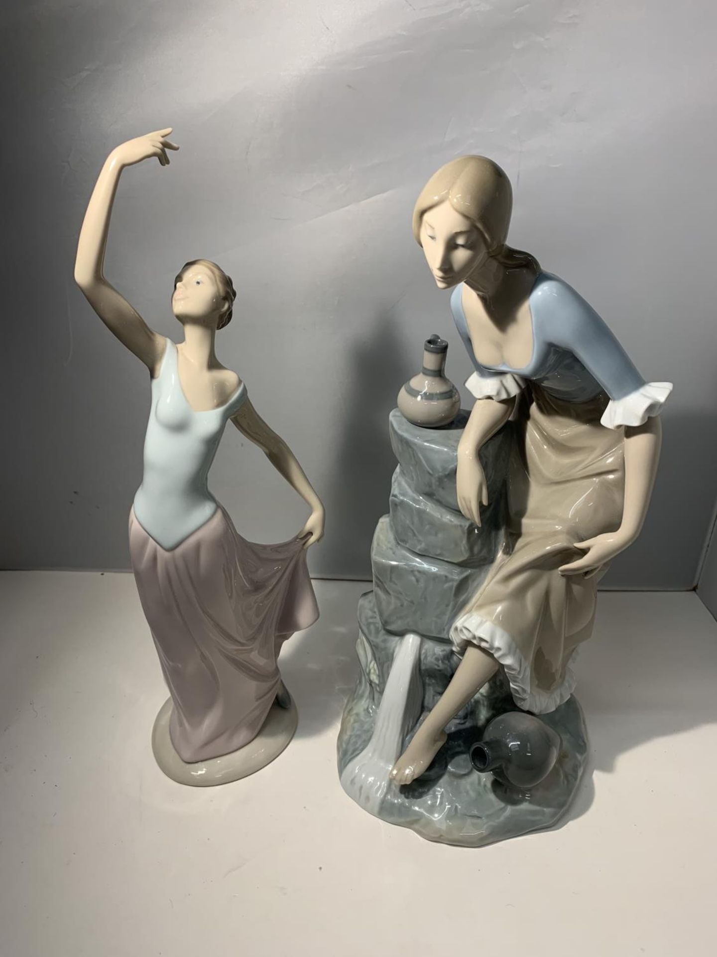 TWO LARGE NAO FIGURINES ONE OF A DANCING LADY AND THE OTHER OF A LADY AT A SPRING