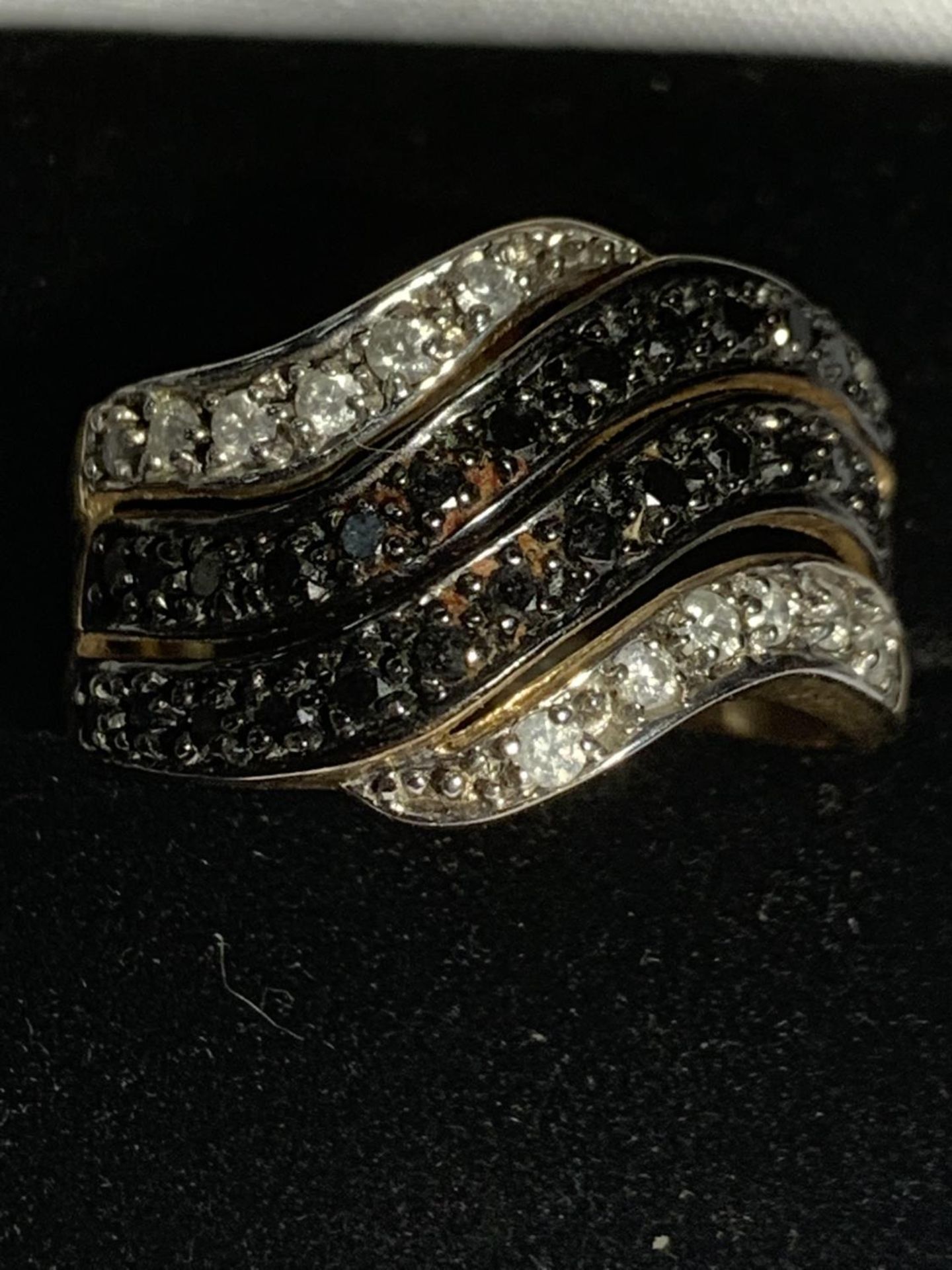 A 9 CARAT GOLD RING WITH TWO LINES OF BLUE STONES AND TWO OF CLEAR ON A TWIST SIZE P GROSS WEIGHT