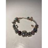 A PANDORA BRACLET WITH FOURTEEN CHARMS AND A SAFETY CHAIN