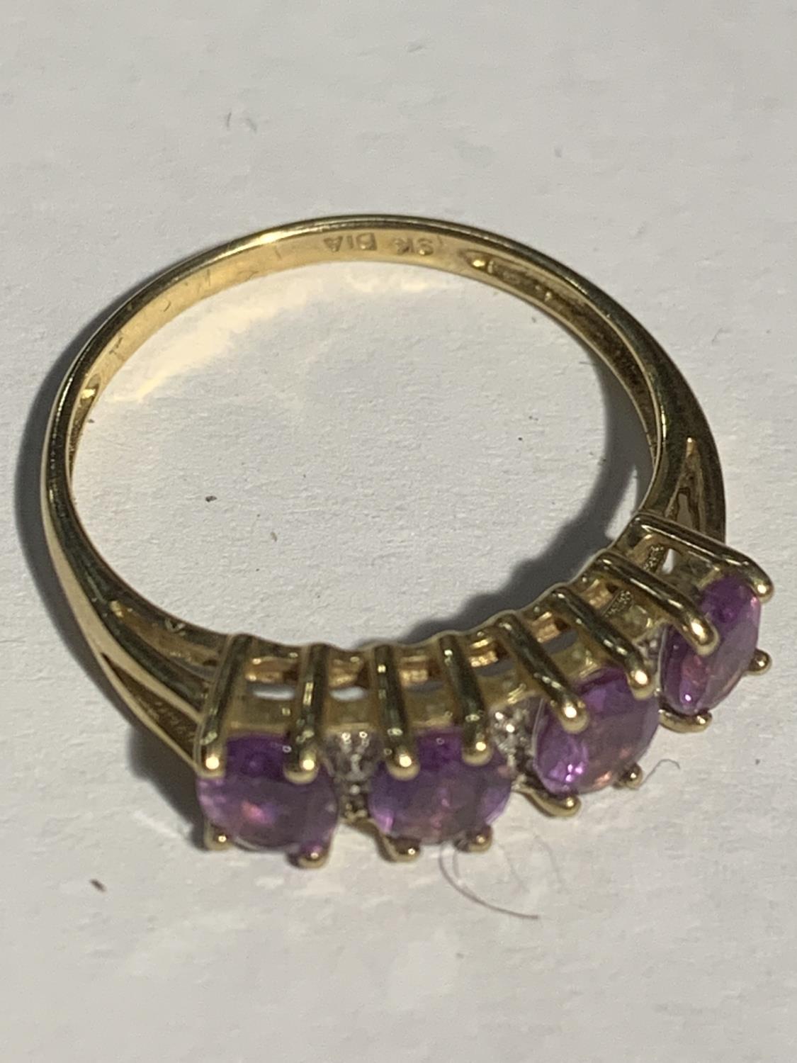A 9 CARAT GOLD RING WITH FOUR IN LINE PURPLE STONES SIZE P GROSS WEIGHT 2.1 GRAMS - Image 2 of 3