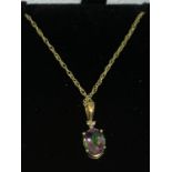 A 9 CARAT GOLD CHAIN WITH A MULTI COLOURED STONE PENDANT AND DIAMOND CHIPS IN A PRESENTATION BOX