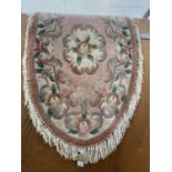 A FLORAL PATTERNED OVAL RUG