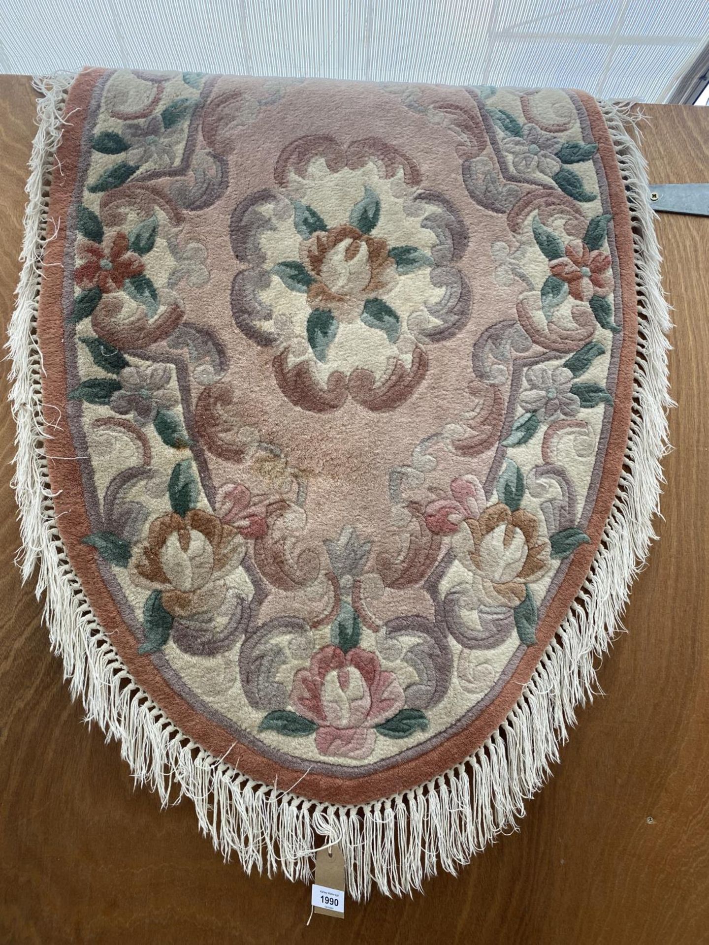 A FLORAL PATTERNED OVAL RUG