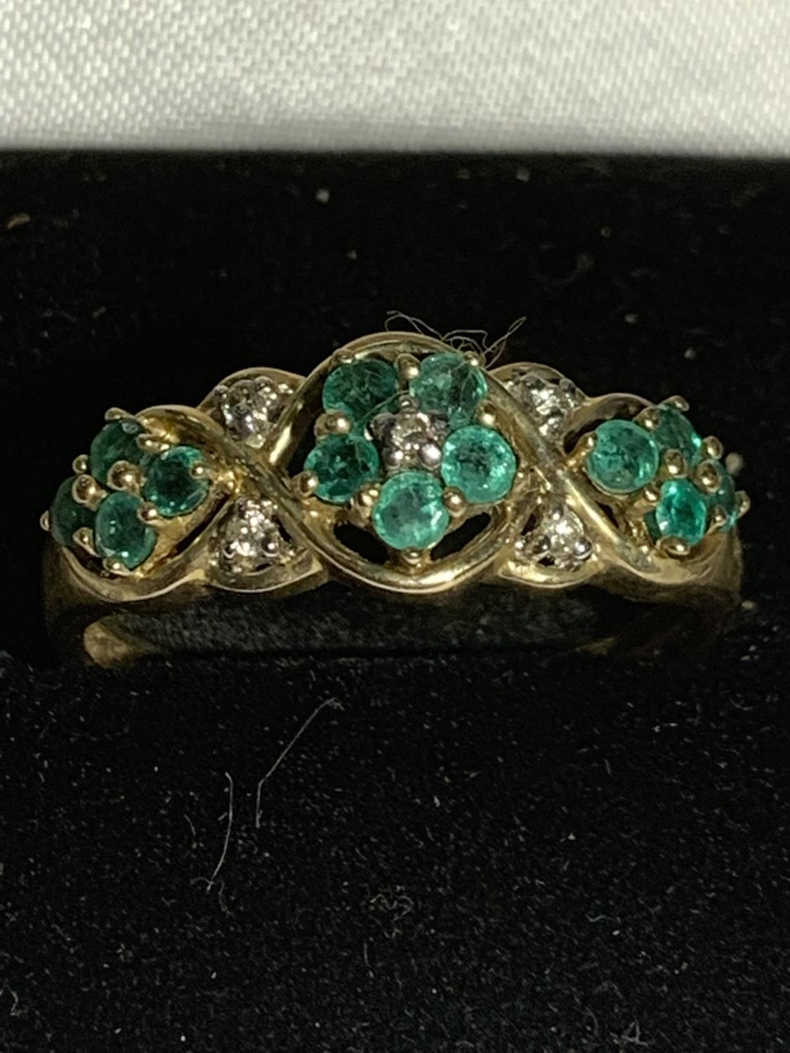 A 9 CARAT GOLD RING WITH GREEN AND CLEAR STONES IN A FLOWER DESIGN SIZE S GROSS WEIGHT 2.7 GRAMS