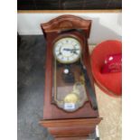 A SMALL DECORATIVE WOODEN WALL CLOCK