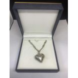 A SILVER NECKLACE WITH A HEAVY DECORATIVE HEART PENDANT IN A PRESENTATION BOX