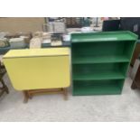 A 1950'S DROP LEAF KITCHEN TABLE IN VIVID YELLOW AND PAINTED FOUR TIER OPEN BOOKCASE