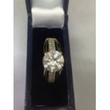 A 9 CARAT GOLD RING WITH A LARGE CENTRE STONE AND STONE CHIP DECORATION ON THE SHOULDERS SIZE M/N IN