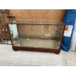 A VINTAGE WOODEN SHOP DISPLAY COUNTER WITH SINGLE GLASS SHELF