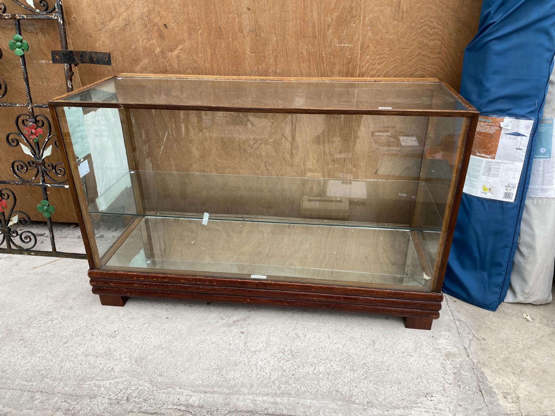 A VINTAGE WOODEN SHOP DISPLAY COUNTER WITH SINGLE GLASS SHELF