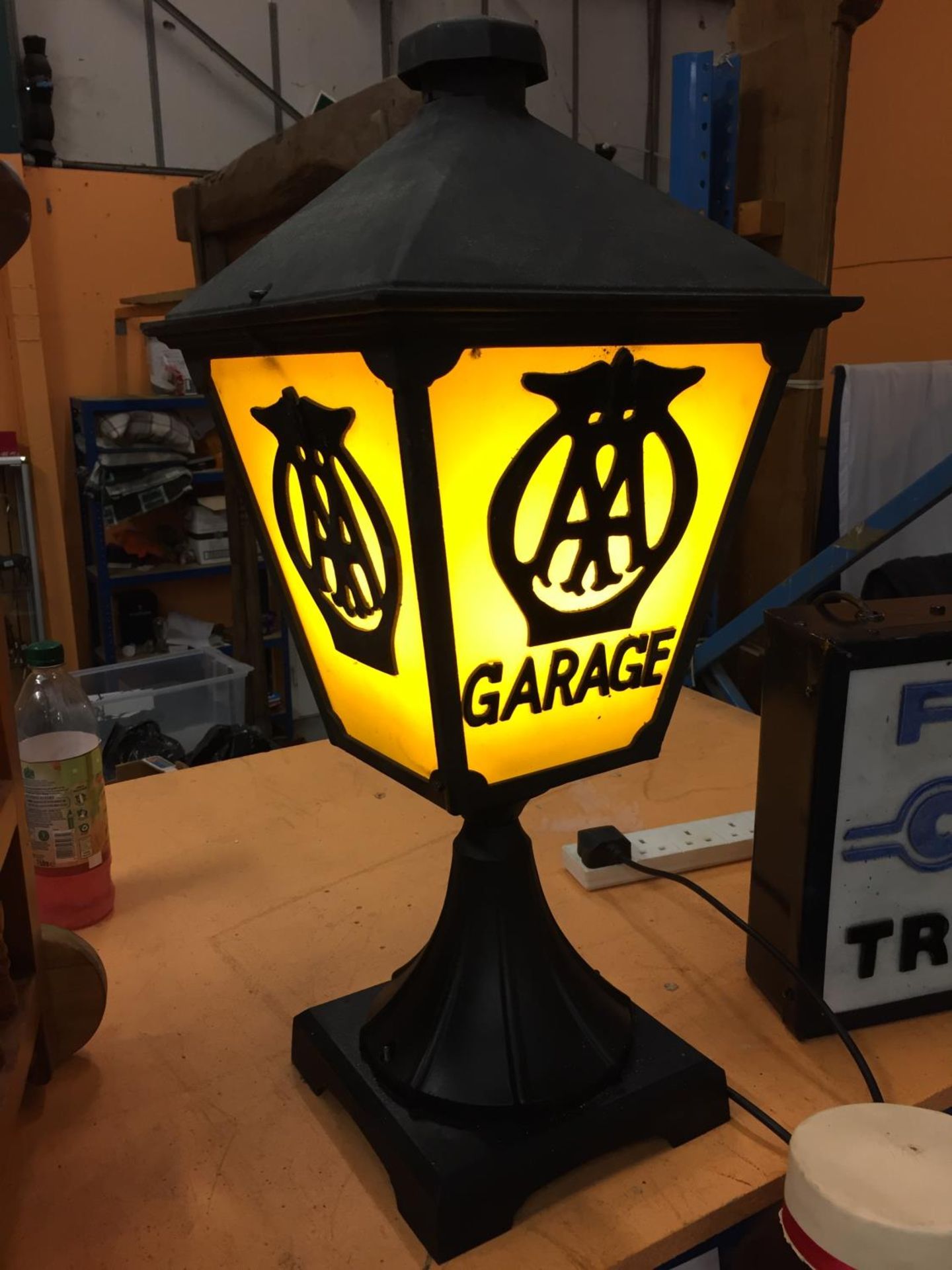 A CAST METAL LAMP WITH AA GARAGE THREE SIDED DETAIL TO PANELS AND BELIEVED IN WORKING ORDER BUT NO