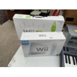 A BOXED NINTENDO WII AND A BOXED WII FIT BOARD