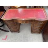 A MAHOGANY SERPENTINE FRONTED TWIN PEDESTAL DESK OF NINE DRAWERS, 45 X 21"