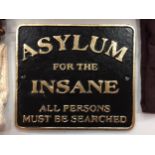 A CAST SIGN SAYING 'ASYLUM FOR THE INSANE'