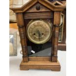 A VINTAGE AMERICAN WOODEN CASE CLOCK WITH A FRONT OPENING FACE