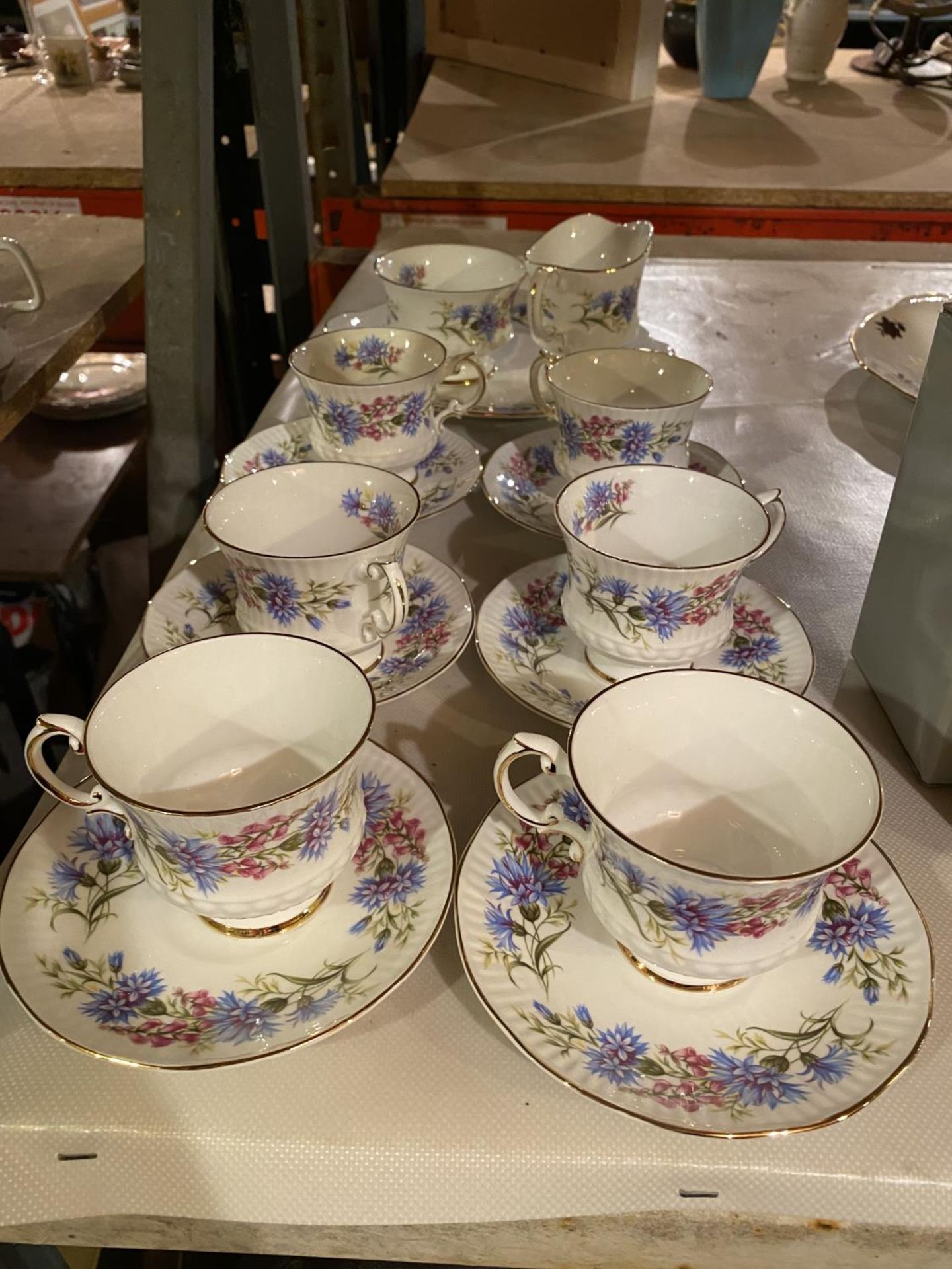 A BONE CHINA PART TEA SET COMPRISING OF SIX CUPS AND SAUCERS, SANDWICH PLATE, MILK JUG AND SUGAR