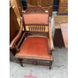 AN EDWARDIAN MAHOGANY ELBOW CHAIR ON TURNED LEGS AND STRETCHERS WITH CARVED TOP RAIL