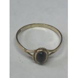 A 9 CARAT GOLD RING WITH A SINGLE DARK STONE SIZE O