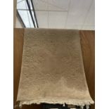 A CREAM FRINGED RUG