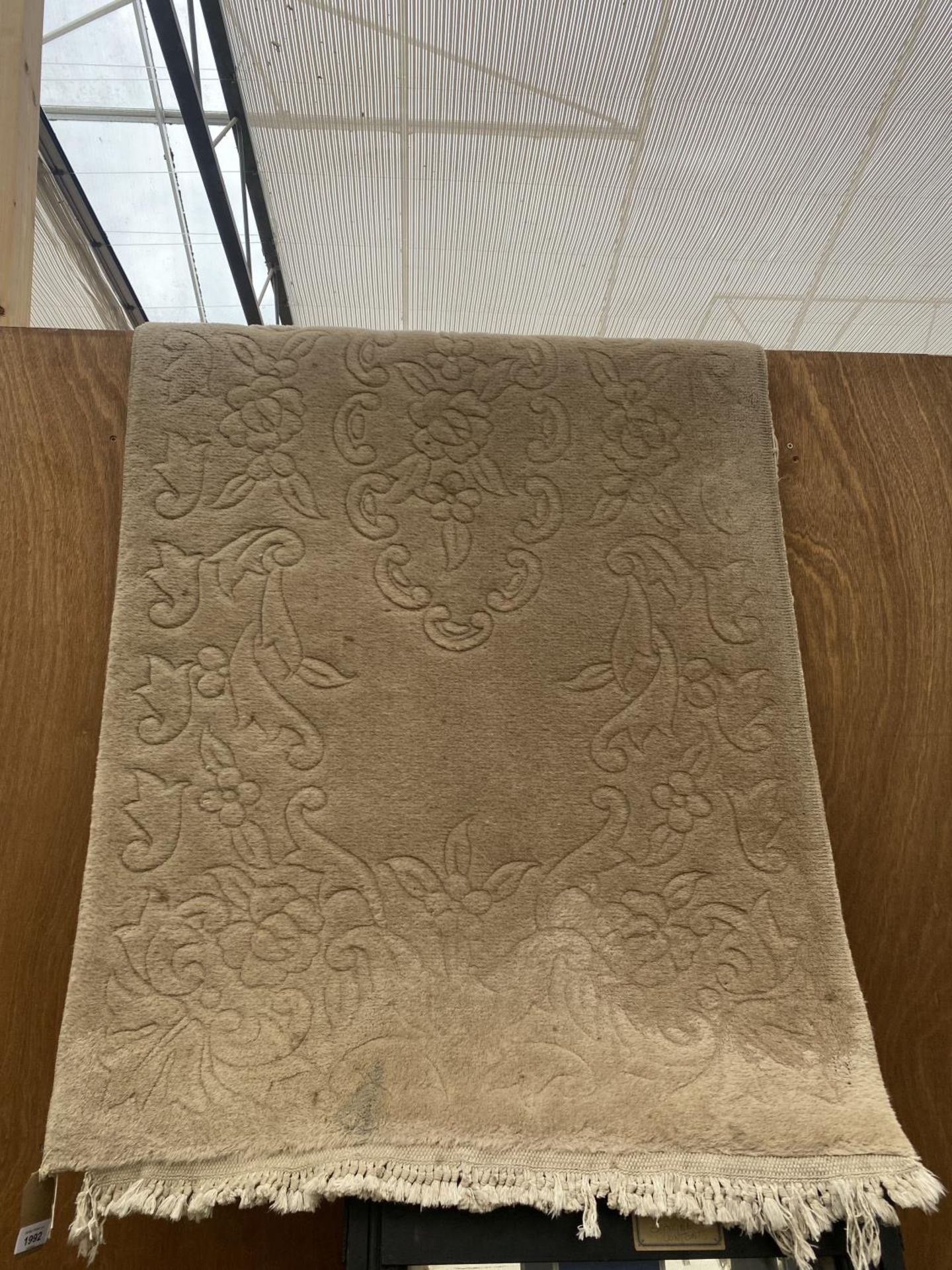 A CREAM FRINGED RUG