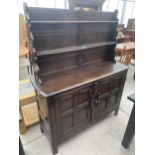 AN ERCOL DRESSER COMPLETE WITH PLATE RACK, THE BASE ENCLOSING TWO CUPBOARDS, 48" WIDE