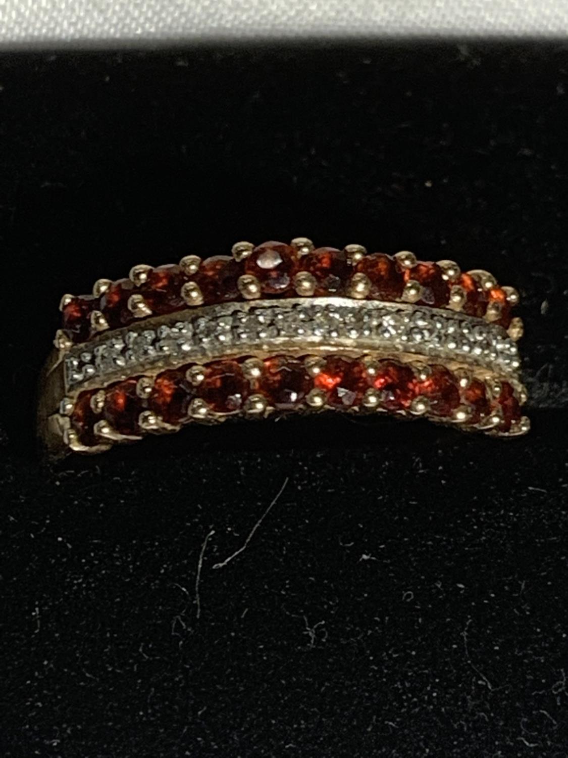 A 9 CARAT GOLD RING WITH TWO LINES OF RED STONES AND A LINE OF CLEAR STONES SIZE P/Q GROSS WEIGHT