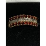 A 9 CARAT GOLD RING WITH TWO LINES OF RED STONES AND A LINE OF CLEAR STONES SIZE P/Q GROSS WEIGHT