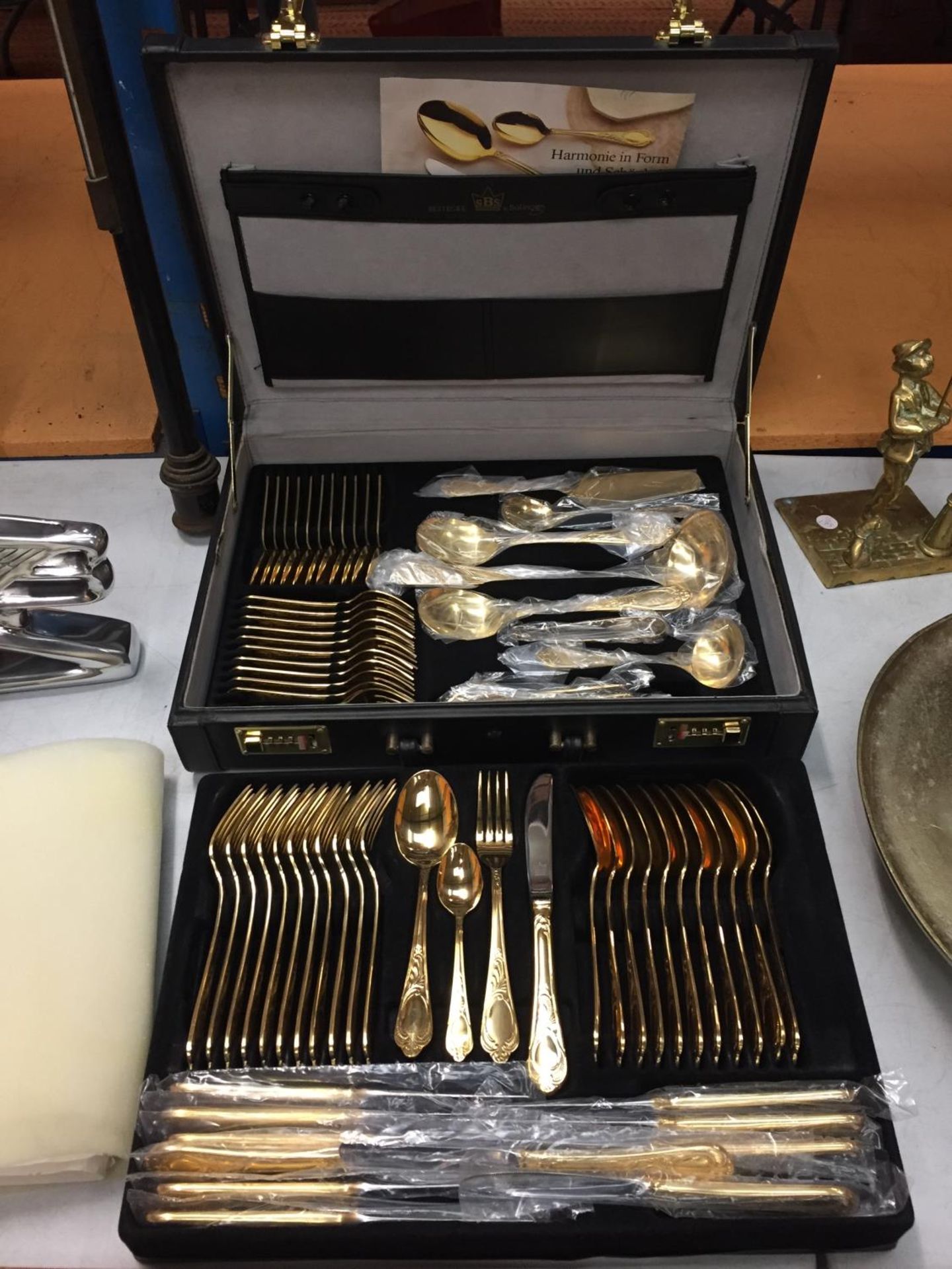 A TWELVE SETTING GOLD PLATED CANTEEN OF CUTLERY WITH SERVING SPOONS,LADELS, CAKE FORKS ETC IN A CASE