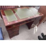 A REPRODUCTION MAHOGANY KNEEHOLE DESK WITH INSET LEATHER TOP