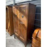 AN EARLY 20TH CENTURY TWO DOOR OAK WARDROBE