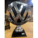 A LARGE DECORATIVE VW LOGO ON A PLINTH SIZE 50 CM