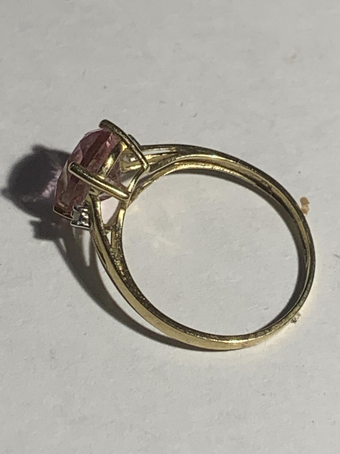 A 9 CARAT GOLD RING WITH A LARGE PINK CENTRE STONE SIZE Q GROSS WEIGHT 1.7 GRAMS - Image 3 of 3