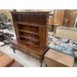 A GEORGE III OAK AND MAHOGANY CROSSBANDED DRESSER ON TURNED FRONT LEGS, THREE DRAWERS AND PLATE RACK