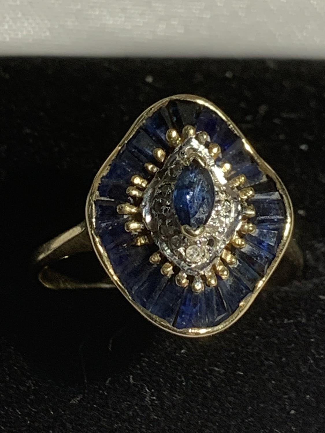 A 9 CARAT GOLD RING IN AN ART DECO STYLE WITH BLUE AND CLEAR STONES SIZE O/P GROSS WEIGHT 2.8 GRAMS