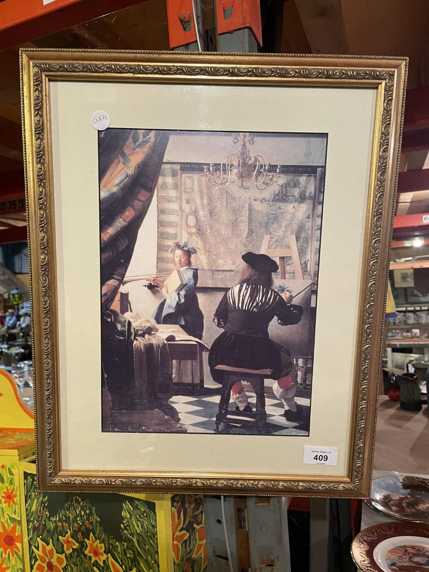 A GILT FRAMED PRINT OF AN ARTIST PAINTING A LADY