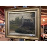 AN ATMOSPHERIC PICTURE OF COWS IN A RIVER WITH A BACKDROP OF A RUINED ABBEY