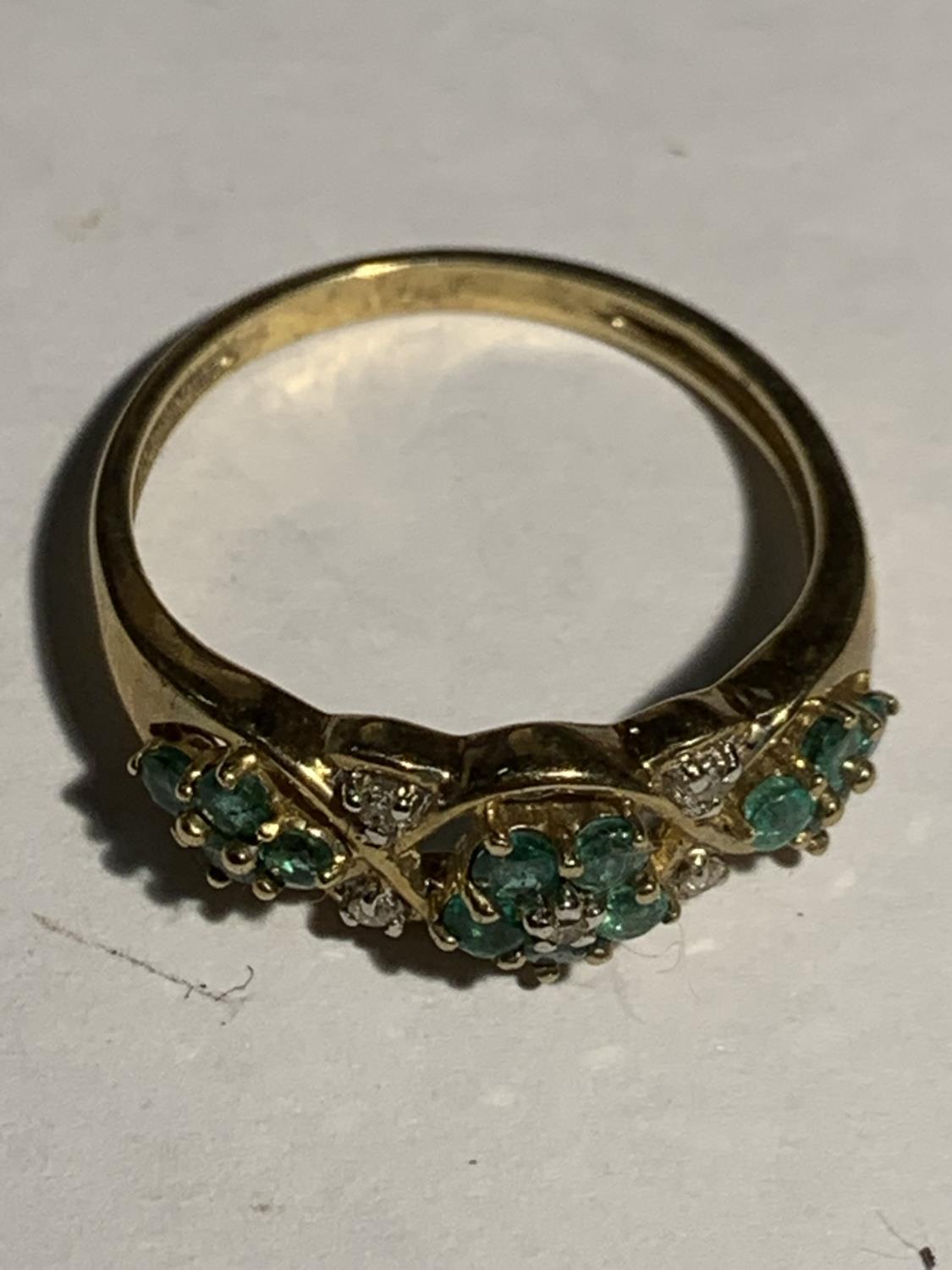 A 9 CARAT GOLD RING WITH GREEN AND CLEAR STONES IN A FLOWER DESIGN SIZE S GROSS WEIGHT 2.7 GRAMS - Image 2 of 5