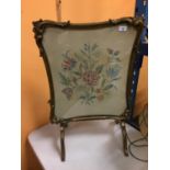 AN ORNATELY FRAMED CROSS STITCHED FIRE SCREEN WITH A FLOWER DESIGN