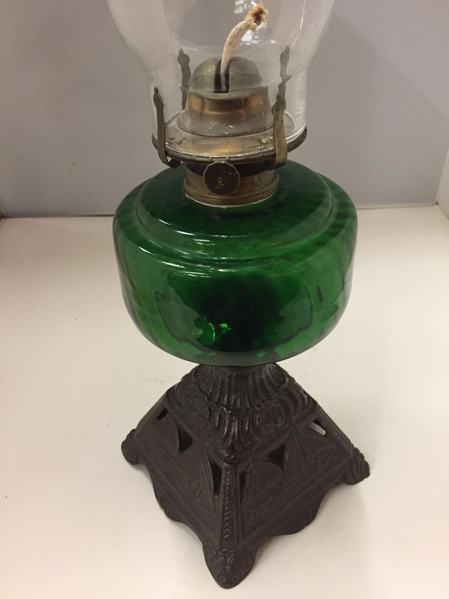 A CAST BASED OIL LAMP WITH A GREEN GLASS BODY AND CLEAR GLASS CHIMNEY - Image 2 of 2