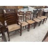 SIX LANCASHIRE STYLE LADDERBACK DINING CHAIRS WITH RUSH SEATS, ONE BEING CARVER