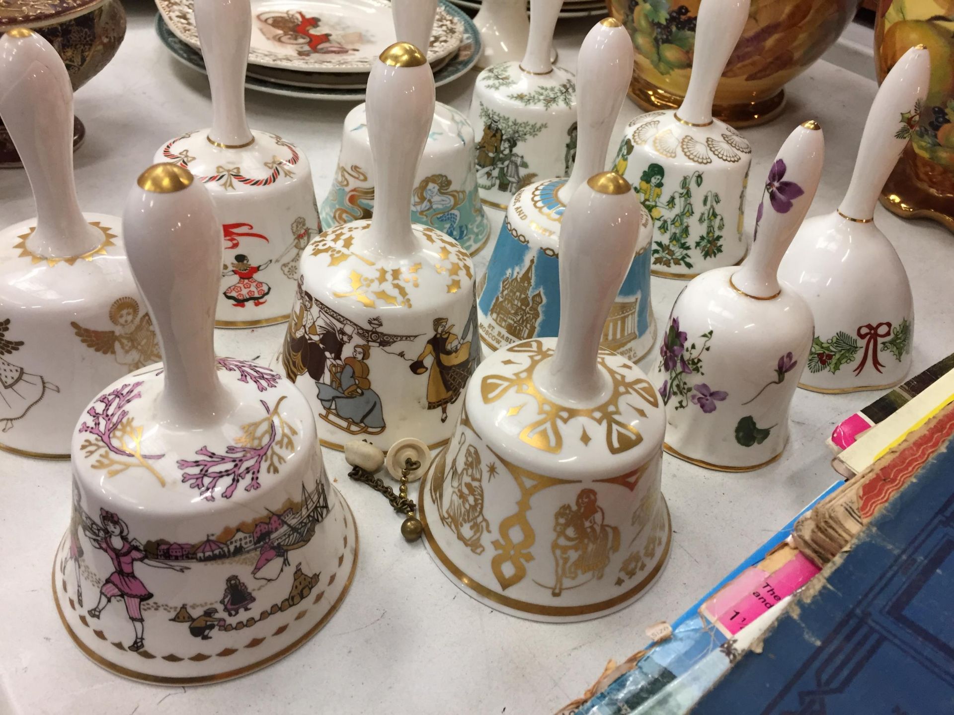 A COLLECTION OF ELEVEN DECORATIVE CERAMIC HAND BELLS - Image 3 of 4