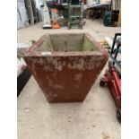 A RED PAINTED CONCERETE PLANTER