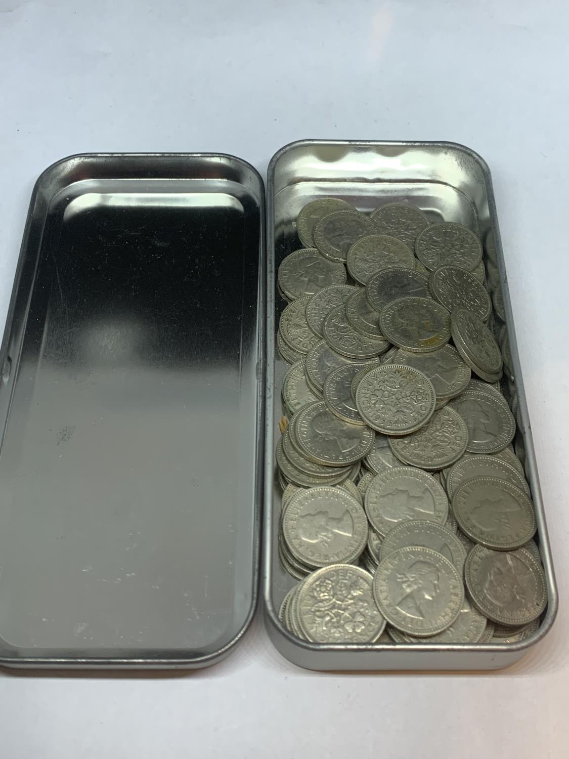 A TIN CONTAINING A LARGE QUANTITY OF SIXPENCES