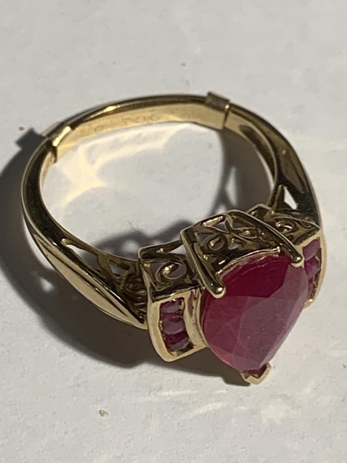 A 9 CARAT GOLD RING WITH A LARGE RED STONE AND THREE SMALL STONES EACH SIDE SIZE R GROSS WEIGHT 4. - Image 2 of 3