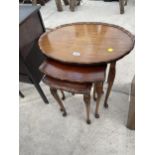 AN OVAL MAHOGANY NEST OF THREE TABLES