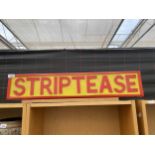 AN ILLUMINATED 'STRIPTEASE' SIGN