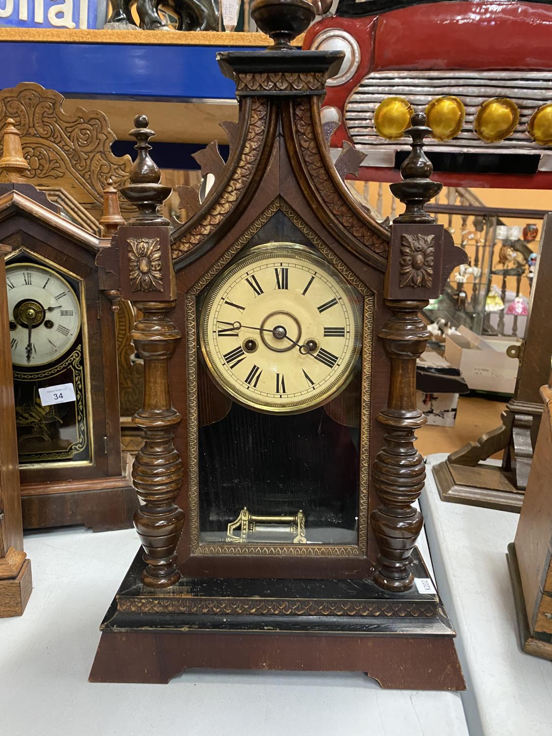 A VINTAGE AMERICAN CLOCK IN A GOTHIC STYLE WOODEN CASE