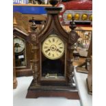 A VINTAGE AMERICAN CLOCK IN A GOTHIC STYLE WOODEN CASE