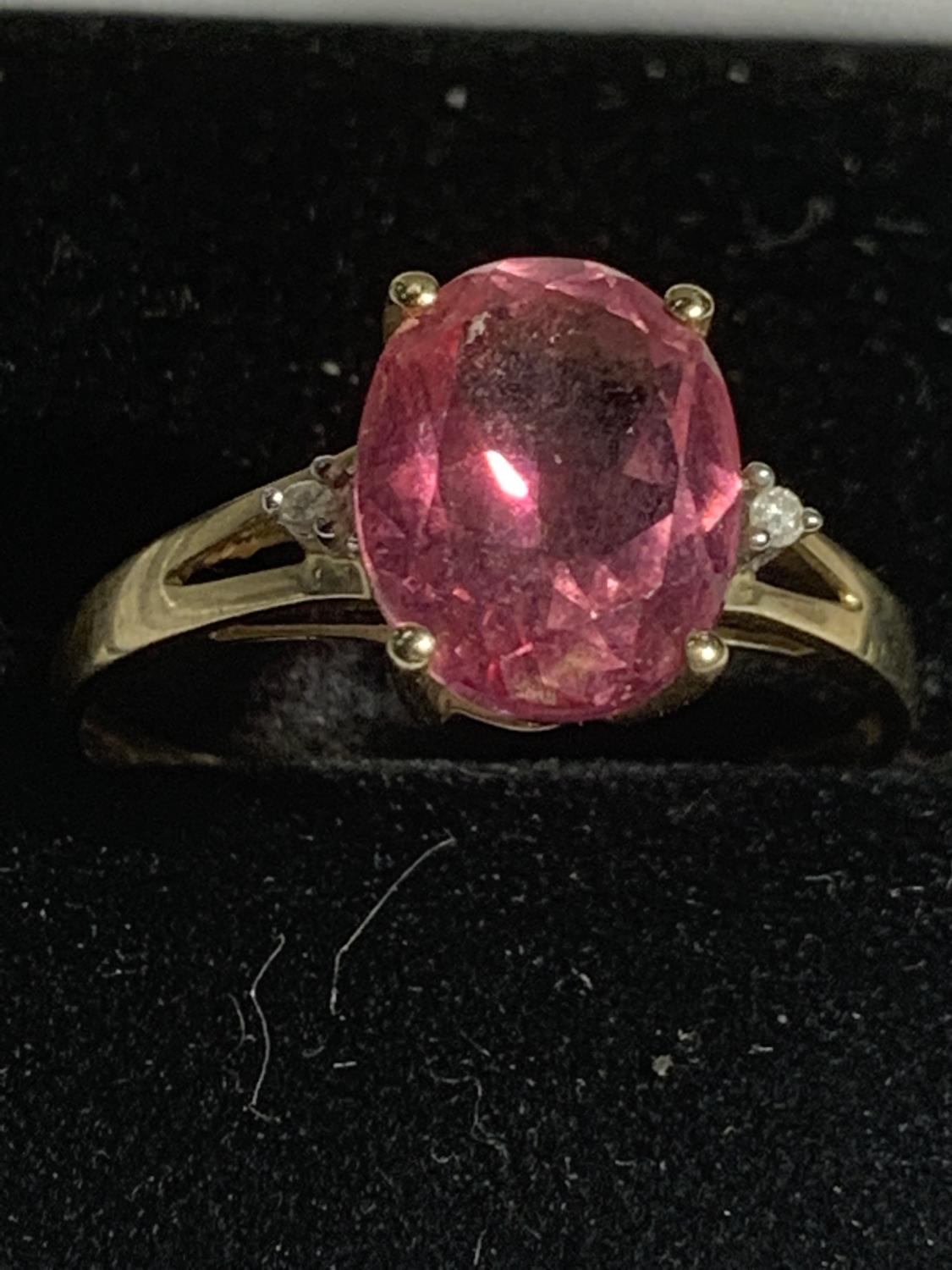 A 9 CARAT GOLD RING WITH A LARGE PINK CENTRE STONE SIZE Q GROSS WEIGHT 1.7 GRAMS